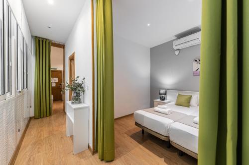 een slaapkamer met een bed met groene zuilen erin bij BNBHolder Apartamentos en Sol Confort 4 in Madrid