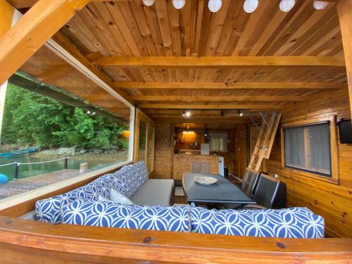 a living room with a couch and a table at Viridian Three Boathouse Micah, PERUCAC LAKE in Perućac