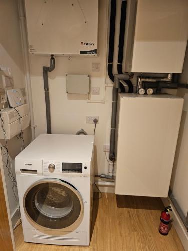 uma máquina de lavar e secar roupa num pequeno quarto em Santina Apartments em Croydon