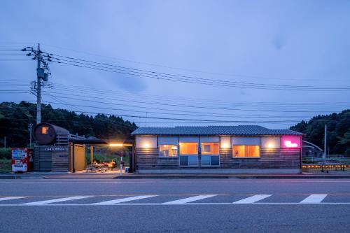 a small building on the side of a street at 一棟貸し宿OH!TOMARI-バレルサウナの有無選択できますo in Nanao
