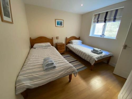 a bedroom with two beds and a window at Karrek View - Trebarwith Strand (Sleeps 8-10) in Treknow