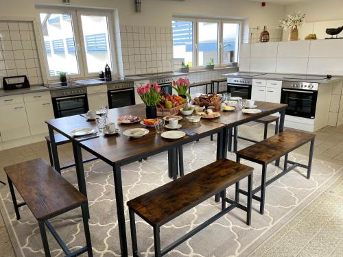 una grande cucina con tavolo e sedie in legno di Boardinghouse Kevelaer a Kevelaer