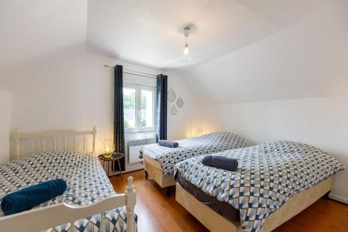 a bedroom with two beds and a window at Gîte du Château in Naours