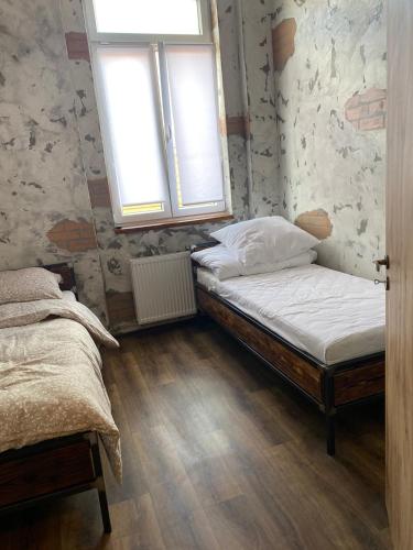 a bedroom with two beds and two windows at Apartmány v Podzámčí v blízkosti zámku Blatná in Blatná