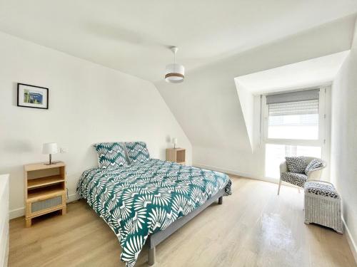um quarto com uma cama, uma cadeira e uma janela em LE GRAND PALAIS - Centre Ville - Palais de justice em Quimper
