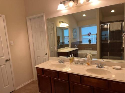 ein Badezimmer mit zwei Waschbecken und einem großen Spiegel in der Unterkunft Spacious Luxury 3BD Oasis Home North Richland Hills Texas in North Richland Hills