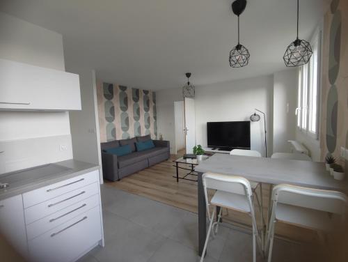 een keuken en een woonkamer met een tafel en stoelen bij Arandes in Dijon