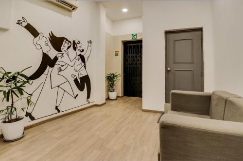 a living room with a large painting on the wall at OYO Townhouse 591 Hotel Woodland in Nagpur