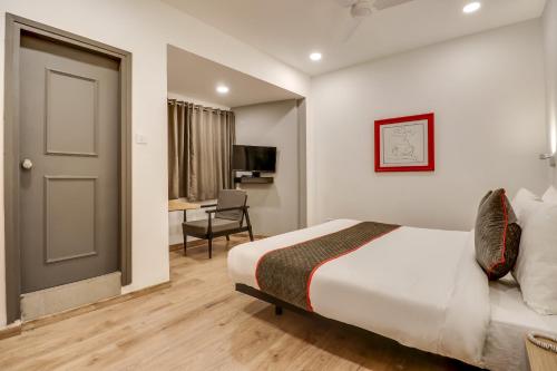 a hotel room with a bed and a desk at OYO Townhouse 591 Hotel Woodland in Nagpur