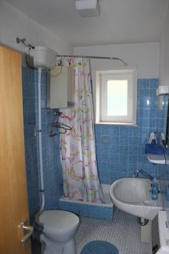 a bathroom with a toilet and a shower curtain at Sleep in Lerbach in Osterode