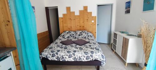 - une chambre avec un lit et une tête de lit en bois dans l'établissement chambre 2 vue lac av piscine, à Prunières