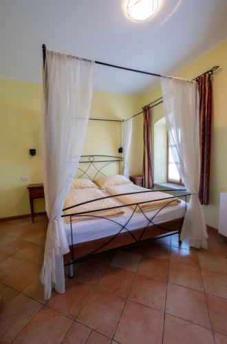 a bedroom with a bed with mosquito netting at Farm Stay Malovščevo in Vitovlje