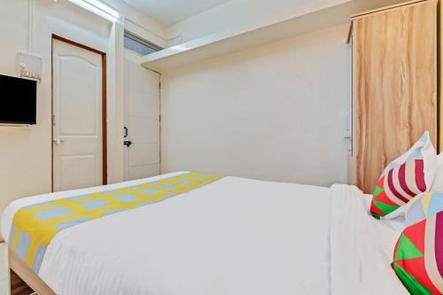 biała sypialnia z łóżkiem i telewizorem w obiekcie OYO Home Saraswati Niwas Vadgaon Budruk Near Fun Time Multiplex w mieście Pune