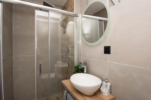 y baño con lavabo blanco y ducha. en Jasmine Suites "By Checkin", en Sissi