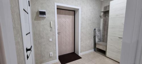 - un couloir avec une porte et un dressing dans l'établissement Однокомнатная квартира в районе ЖК Аружан, à Kökşetaw