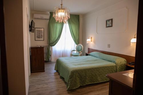 a hotel room with a bed and a chandelier at Hotel Park Ge.Al. in Città di Castello