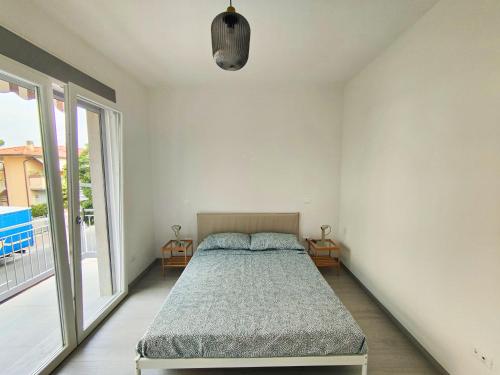 a bedroom with a bed and a large window at CYTRUS apartament in Marina di Massa