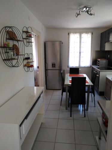 une cuisine et une salle à manger avec une table et un réfrigérateur dans l'établissement Appart du 21, à Sainte-Marie-aux-Mines