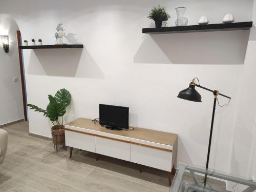 a living room with a desk with a tv on it at Arco Centro Cádiz in Cádiz