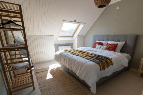 1 dormitorio con 1 cama con escalera y ventana en Gastenkamers Ten Huyze Marchandise, en Brujas