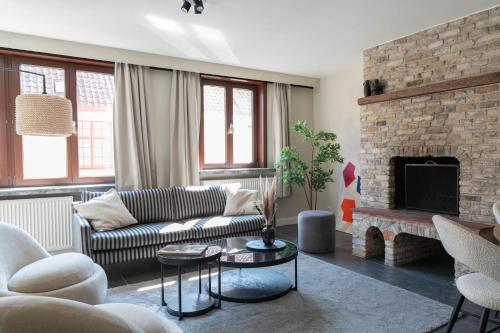 a living room with a couch and a fireplace at Gastenkamers Ten Huyze Marchandise in Bruges