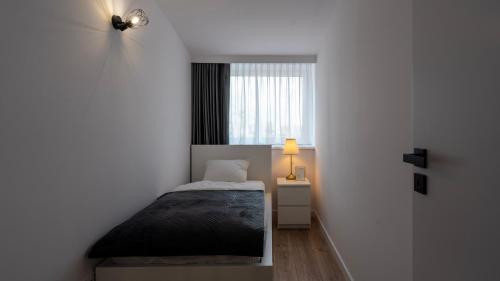 - une petite chambre avec un lit et une fenêtre dans l'établissement Work & Travel _ EcoStay _ Środa Wielkopolska, à Środa Wielkopolska