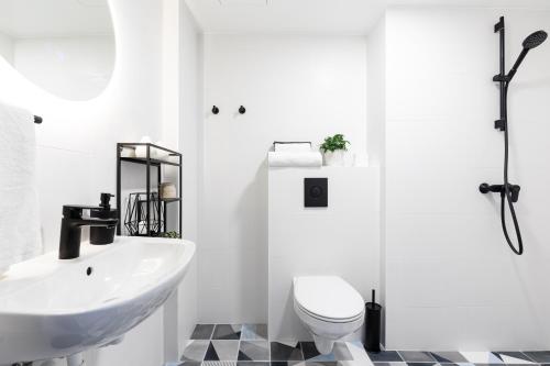 a white bathroom with a sink and a toilet at Rare Apartments - Self Check-In Microapartments in Tartu