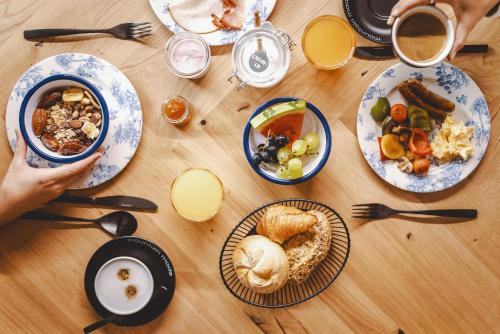 a wooden table topped with plates of food and drinks at The Gast House Zell am See in Zell am See