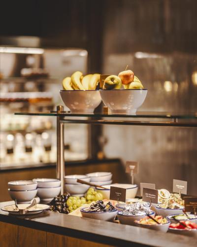 a display of food on a shelf with bowls of fruit at The Gast House Zell am See in Zell am See