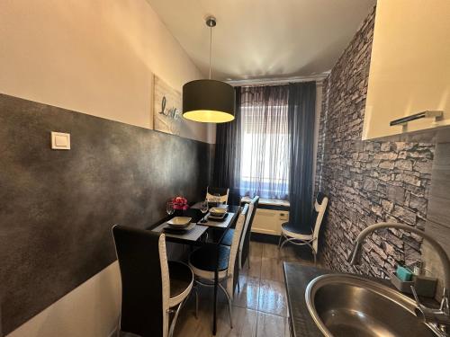 a kitchen and dining room with a table and a sink at Kitty Downtown Apartman in Debrecen