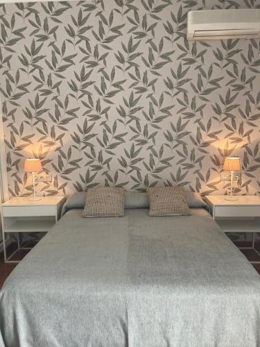 a bedroom with a bed with two tables and a wall at Las Américas - Mares in Torre del Mar
