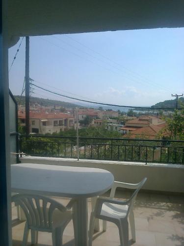 einen Tisch und zwei Stühle auf einem Balkon mit Aussicht in der Unterkunft Appartement Epidaure vue sur mer 4 pers in Antikes Epidauros