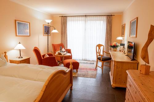 a hotel room with a bedroom with a bed and a desk at Hotel Haferland in Wieck