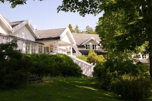 dom z białym płotem na podwórku w obiekcie Jegtvolden Fjordhotell w mieście Straumen