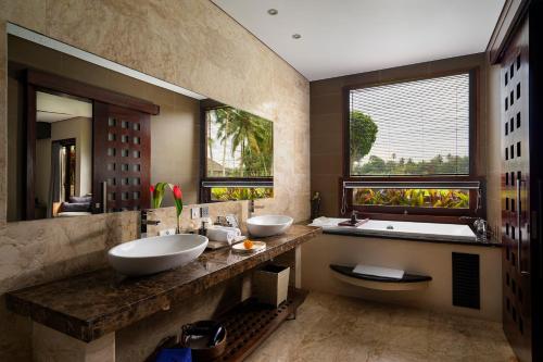 baño con 2 lavabos, bañera y ventana grande en Luxe Villas Bali, en Ubud