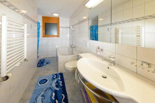 uma casa de banho branca com um lavatório e um WC em Schmiedstube 420 em Grächen