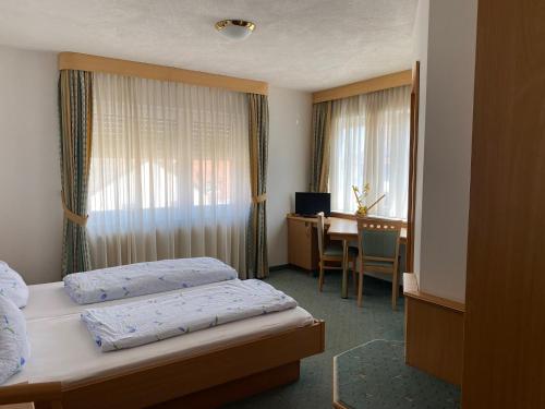 Habitación de hotel con 2 camas y escritorio en Landgasthaus zum Hirsch en Ramsen