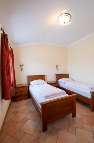 two beds are in a room with a tiled floor at Farm Stay Malovščevo in Vitovlje