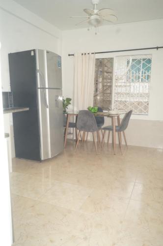 cocina con nevera y mesa con sillas en Apartamento el Calamar, en Cartagena de Indias