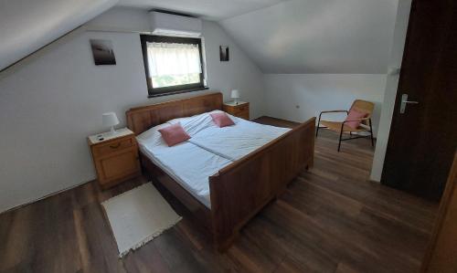 1 dormitorio con cama, ventana y silla en Holiday home Franky en Varaždin Breg