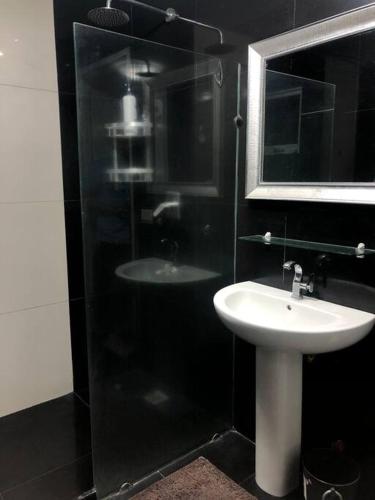 a bathroom with a sink and a glass shower at Sheryll Escapes - Kandi comfortable 1bedroom, king bed, housekeeping in Angeles