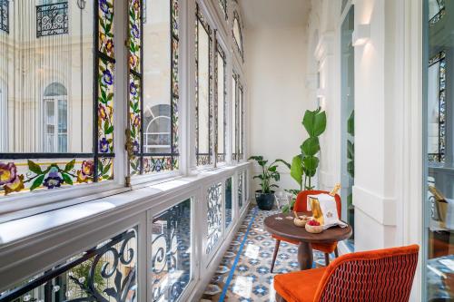 a hallway with stained glass windows and a table at Palacio Gran Vía, a Royal Hideaway Hotel in Granada