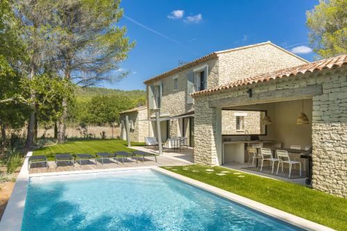 a house with a swimming pool in front of a house at L'Instant Luberon in Gordes