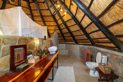 Kariba的住宿－Hornbill Lodge，一间带两个卫生间的浴室和木制天花板
