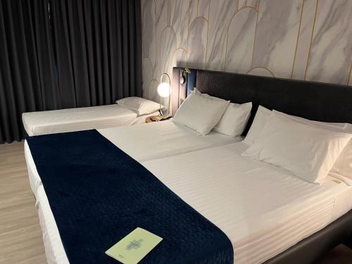 a hotel room with two beds with a blue blanket at Silken Luis de León in León