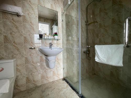 y baño con aseo, lavabo y ducha. en Homestay Bai Chay Ha Long ( Ocean View) en Ha Long