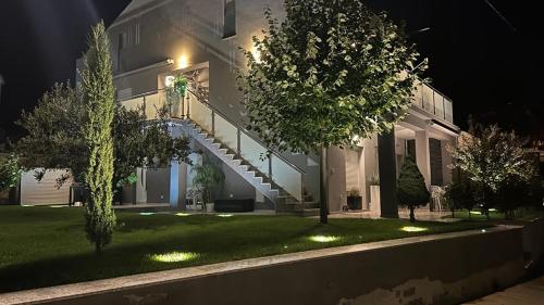 a house with a staircase in the yard at night at Apartmani Deluxe in Jasenice
