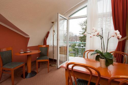 Zimmer mit einem Tisch, Stühlen und einem Fenster in der Unterkunft Hotel Spa Hévíz in Hévíz