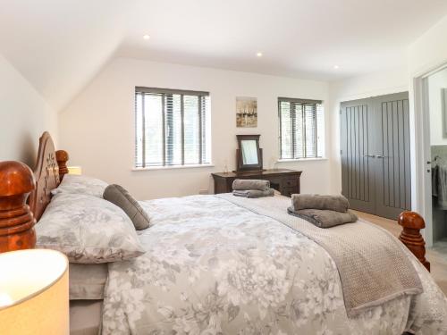 a bedroom with a large bed and a desk at Oak Tree House, 1 Homestead Gardens in Filby