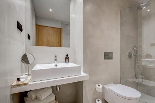 a white bathroom with a sink and a toilet at Acta The Clover in Porto